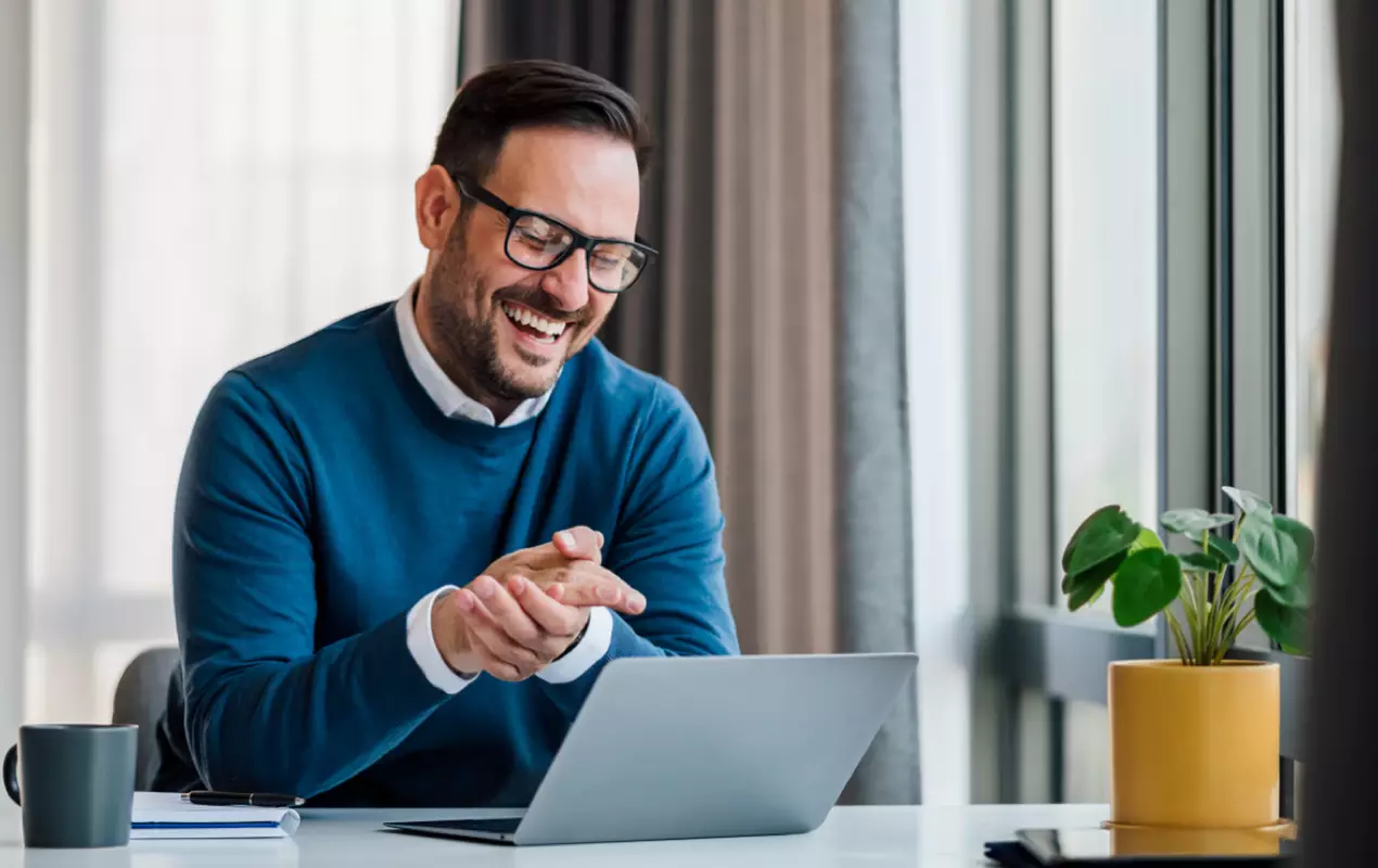 Man smiling and using laptop