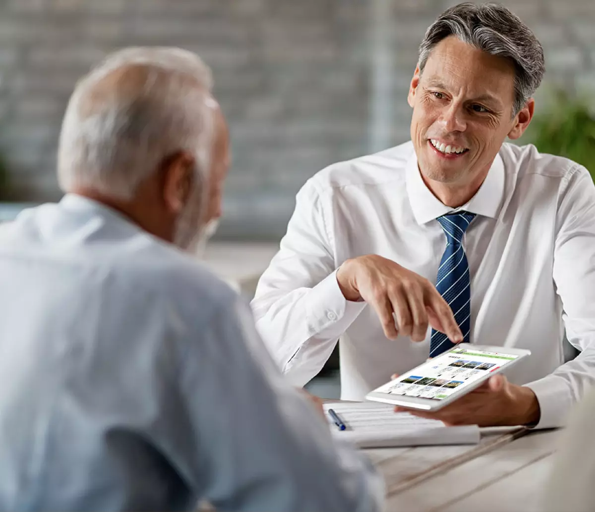 Real estate agent using tablet with customer