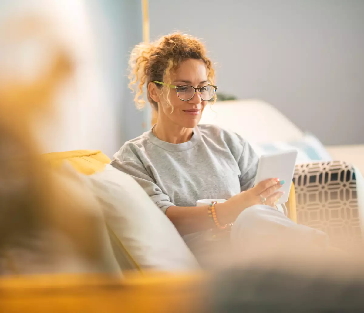 Woman on couch using tablet