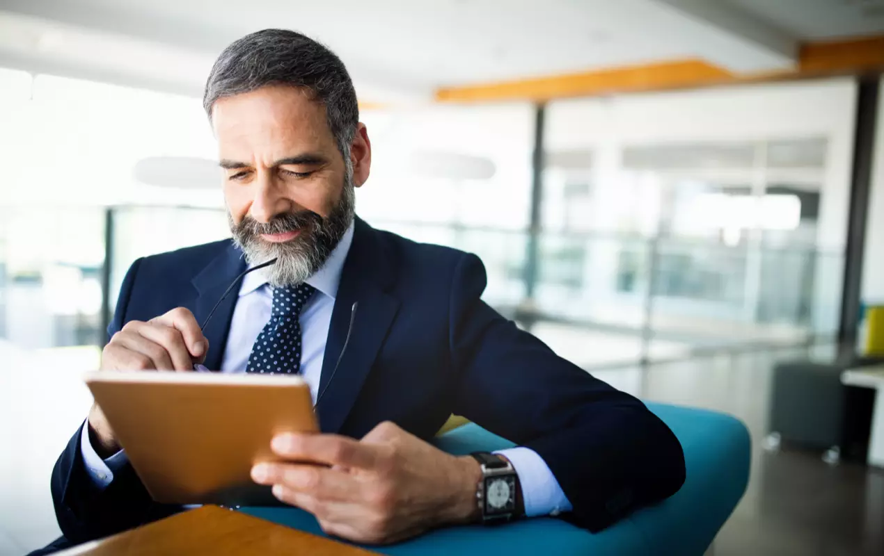 Man in suit using tablet, Real Estate Transaction Management Software