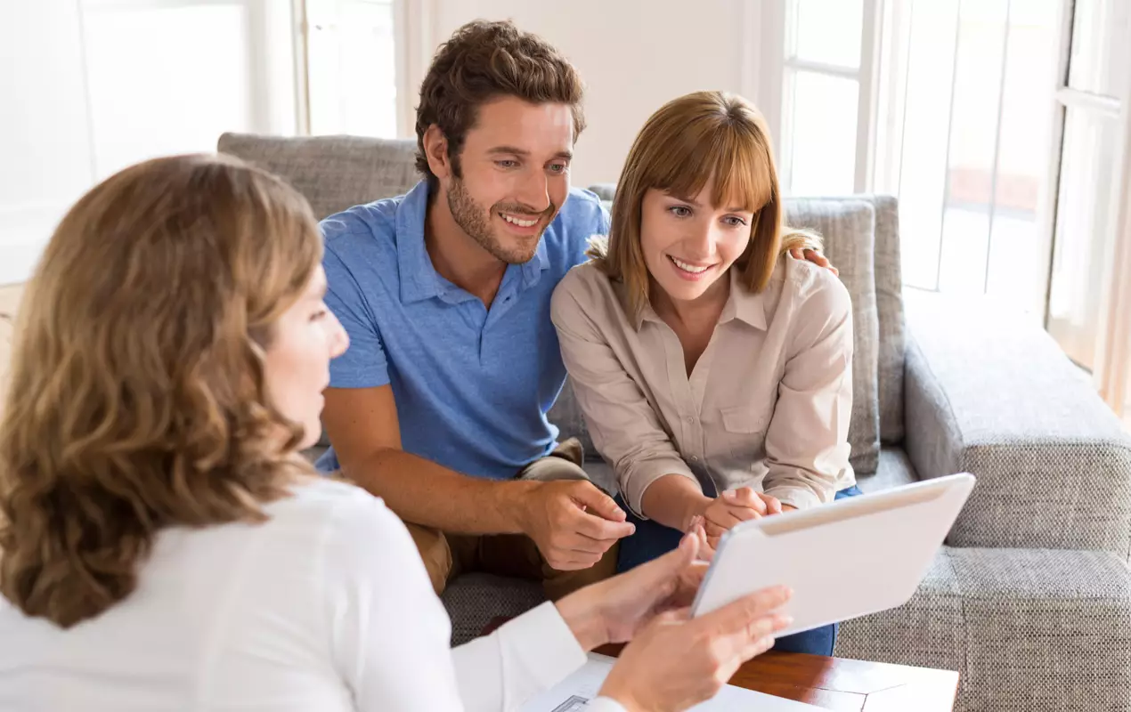 Couple and real estate agent looking at tablet